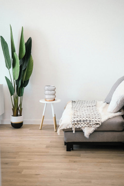 Wohnzimmer im Tageslicht mit skandinavischen Möbeln und Designlampe – ruhige Atmosphäre, Fokus auf Licht und Form.