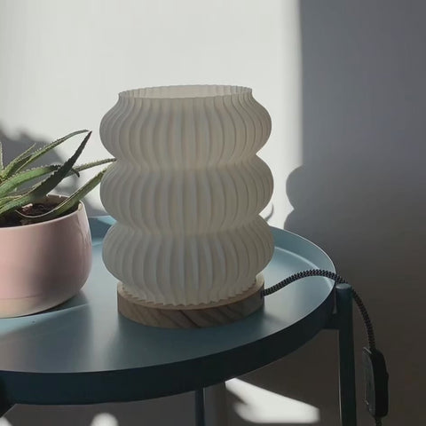 Wohnzimmer im Tageslicht mit skandinavischen Möbeln und Designlampe – ruhige Atmosphäre, Fokus auf Licht und Form.